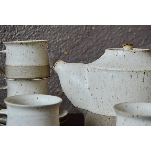 This charming tea service exudes a charm imbued with softness and serenity. Made of ceramic, the pieces are partially...