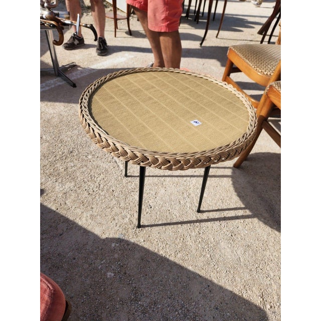 Small table in wood, wicker and wrought iron painted black. The round top is covered with an imitation wicker embossed...