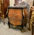 Magnificent French Rococo-style commode chest featuring an elegant curved silhouette, luxurious marble top, and richly...