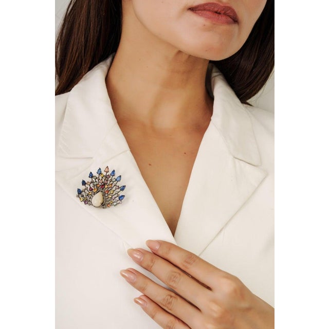 Crafted in 925 sterling silver, this striking brooch showcases a vibrant 15-carat combination of opal and multi-sapphires,...
