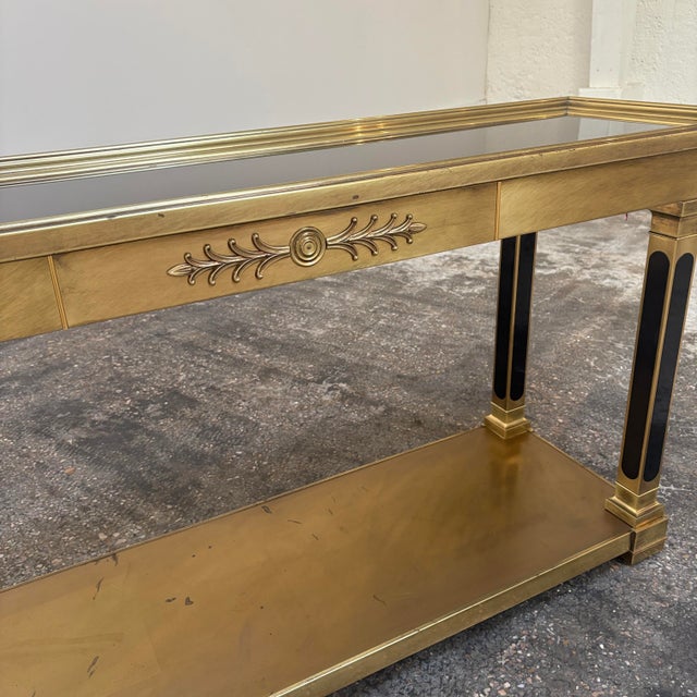 Make an entrance with this neoclassic style Attributed to Mastercraft brass and black glass console table. Four columns...