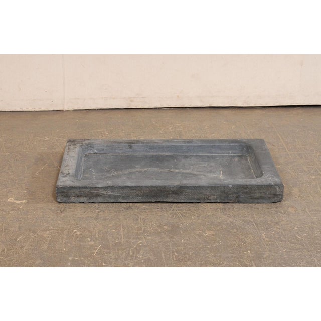 A Spanish carved-stone sink, with shallow basin and off-set drain hole, from the 19th century. This antique hand-carved...