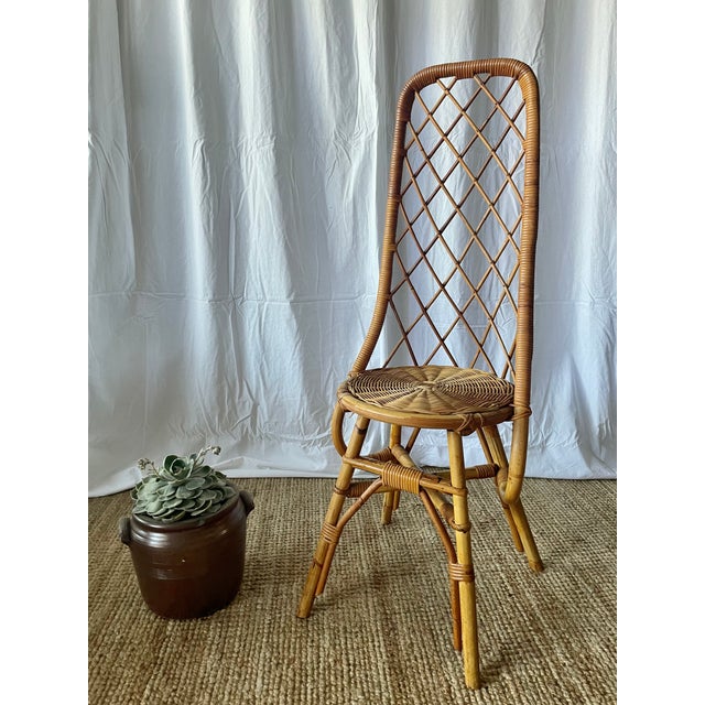 Natural rattan chair with a high, cross-braced back in the style of Louis Sognot, vintage 1960s/70s. A sure bet for...