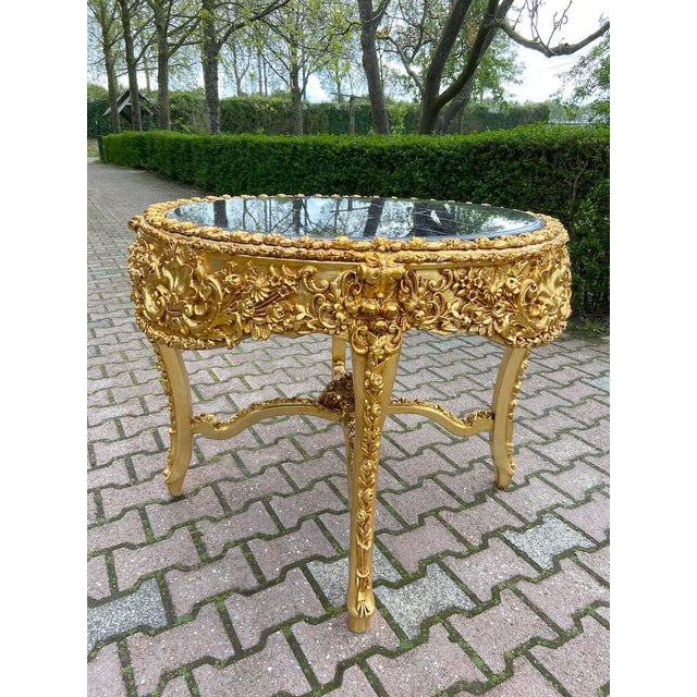 A striking 1970s Italian dining set in an opulent Baroque/Rococo Revival style, featuring a richly carved gold leaf dining...