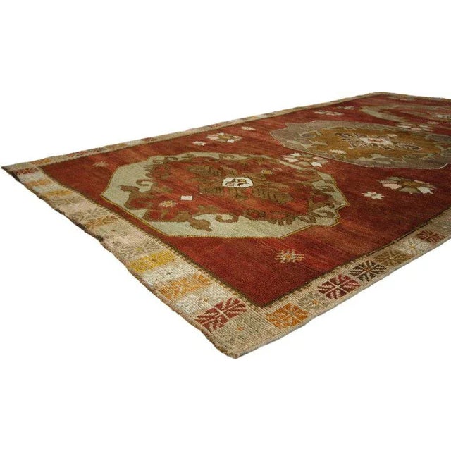 This hand knotted wool vintage Turkish Oushak rug features three large hexagonal floral medallions spread across an...