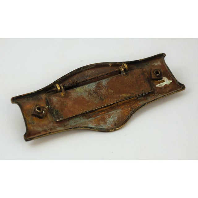 This unique late 19th-century English Victorian brass door knocker also acts as a mail slot. There is some slight rusting,...