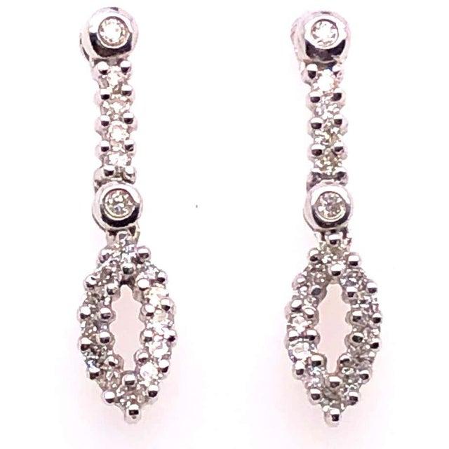 14 Karat White Gold Free Style Drop Earrings with Diamonds. 0.50 total diamond weight. 2.40 grams total weight.