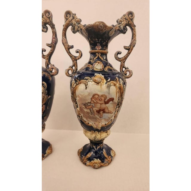 This listing features a pair of Rococo style vases that are a beautiful cobalt color with depictions of two pairs of...