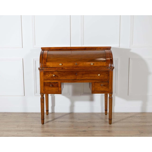 A refined Charles X period cylinder desk in solid walnut, crafted in Italy in the 19th century. The desk features a...