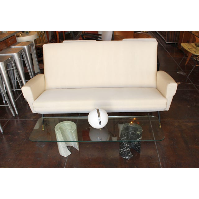 Italian 1950s elegant sofa.Upholstered in Italian material Pana Cota. Brass and metal legs refurbished. Sofa is...
