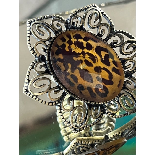 Oversized Y2K statement ring featuring an oval leopard-print cabochon with a faceted clear top layer, likely resin or...