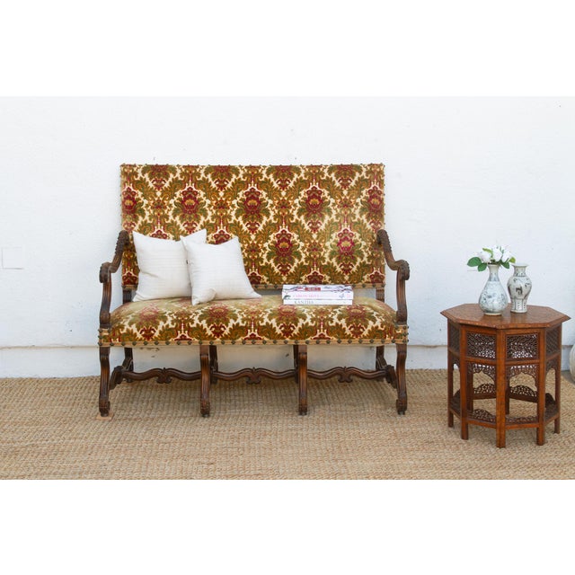 A settee this size, carved this deeply, doesn't come along in every shipment. Its arms scroll out in tight, ram's-horn...