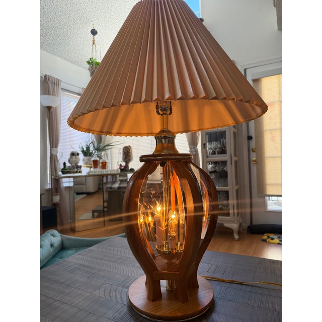 Vintage pair of Anthony California lamps with an oakwood frame and smoked etched glass panels surrounding a unique...