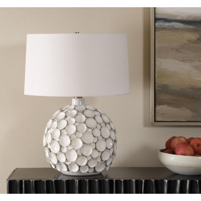 The Hartley Table Lamp features a ceramic base adorned with layered petals in a warm white glaze, accented with antique...