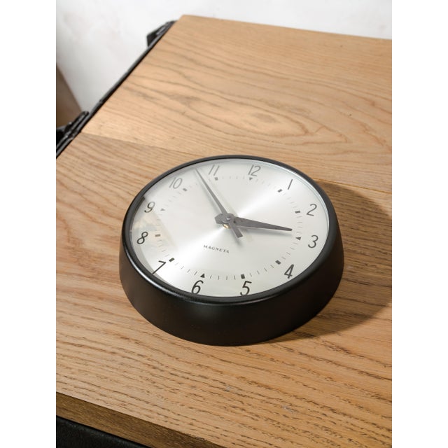 An original Magneta clock, once a clock in a post office, telephone exchange, or factory setting, finished in satin black...