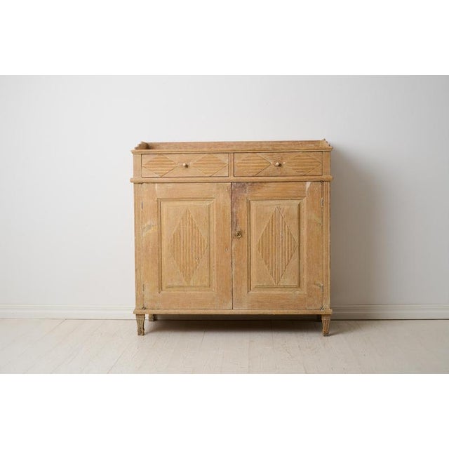 Early 19th century sideboard in gustavian style. Made in northern Sweden from solid pine around 1820. The sideboard has...