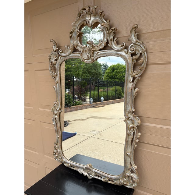 An exceptional late 20th century French Louis XV silvered giltwood mirror with richly carved Rococo detailing and a...