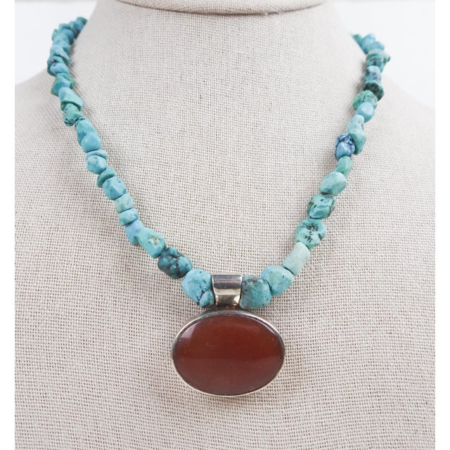 Contemporary sterling silver, turquoise nugget necklace with bezel set carnelian cabochon pendant. Marked 925 sterling...