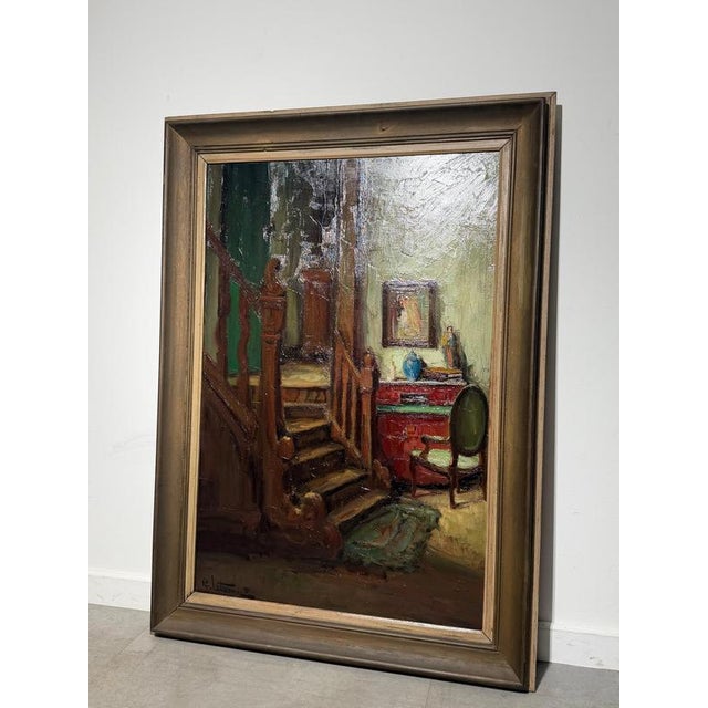 An evocative oil on canvas by Richard Leutenez depicting a warmly lit domestic interior centered around an elegant wooden...