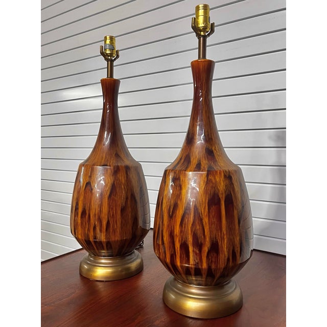 Pair of mid-century modern drip glaze table lamps. Brown tones throughout the glaze. This pair has a brass finish at the...
