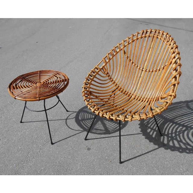 This set consisting of a large rattan chair and a small table, are attributed to Ico Parisi. The legs are in black metal....
