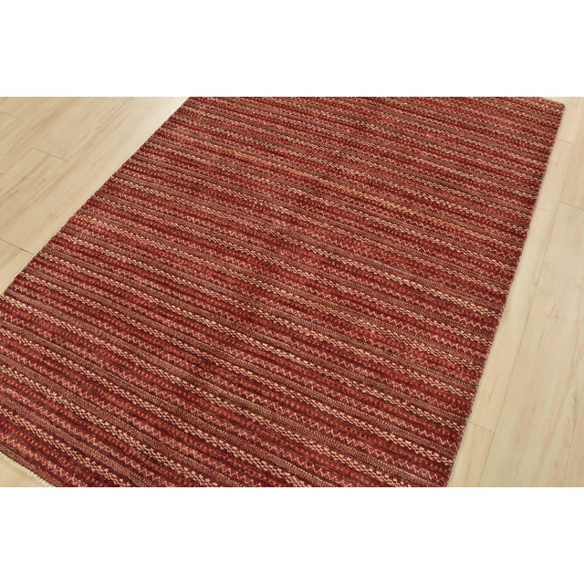 This contemporary Gabbeh rug is hand-knotted with an all-wool pile on a cotton foundation. This oriental rug features a...