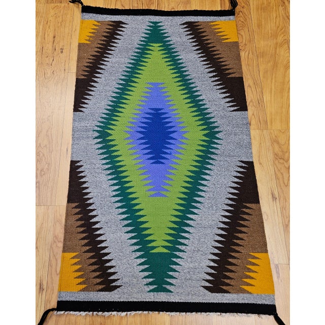 A stunning mid-20th century Navajo style weaving from the American Southwest, this vibrant rug showcases an extraordinary...