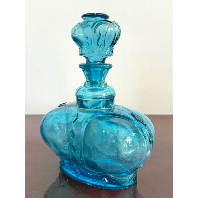 Bold and sculptural, this vintage bottle is molded in the shape of a royal crown, complete with a stopper echoing the...
