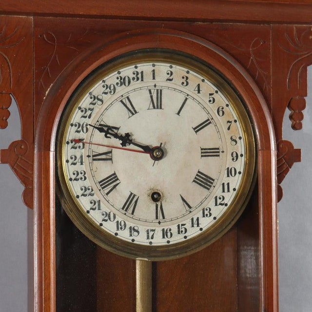 An oversized antique calendar wall clock, crafted in the American Victorian style, circa 1890. The case is constructed...