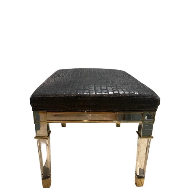 A refined bench ottoman from the Caracole Classic collection, featuring a sleek rectangular silhouette elevated by a...