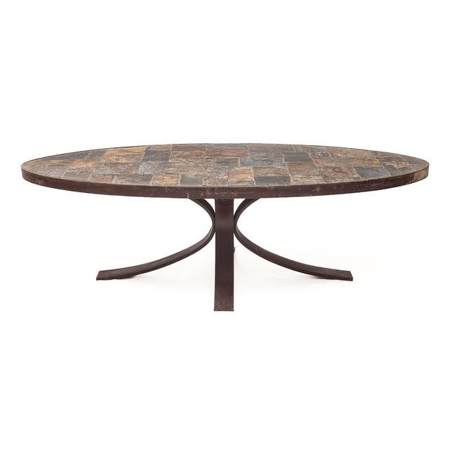 Oval Brutalist coffee table, in the style of Jean Jaffeux. Wrought iron base. Raw slate top. Iron rim. Circa 1950
