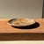 A small, round tray, dish, or plate made of petrified wood. Petrified wood is a fossilized wood (from the same family as...