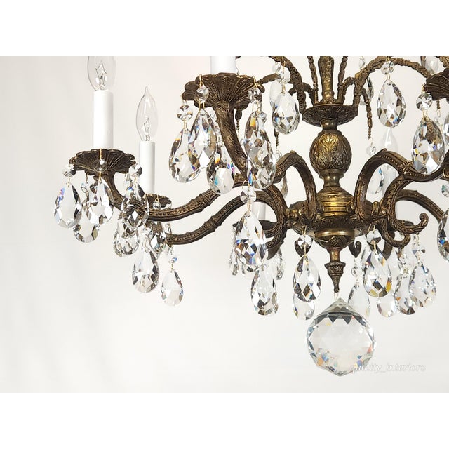 This Antique 8 Arm Sensational Dark Patina Brass Cut Lead Glass Crystal Chandelier from the 1950s exudes elegance and...