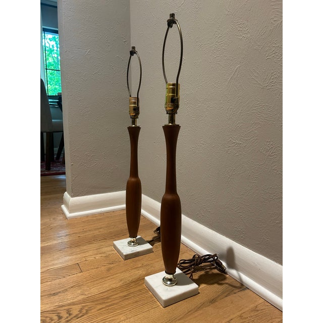 Pair of mid-century modern table lamps. Bases are walnut and marble with plated brass accents. Original wiring and patina.