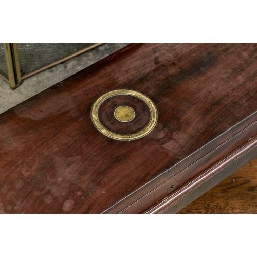 A wooden campaign-style box or writing case on a stand in a dark mahogany with brass corner mounts, a recessed brass...