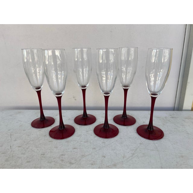 Set of 6 champagne glasses. Red foot and stem clear bowl. Standing 8.75” tall , base is 2.75” and a rim of 2” diameter.