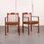 Danish modern teak dining chairs with curved crest rails, vertical spindle backs, and upholstered floating seats. The...