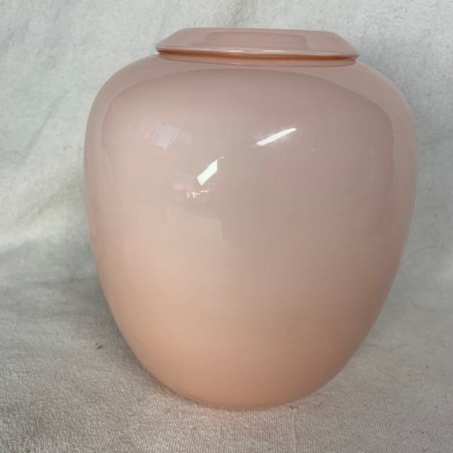 This is a vintage Larry Laslo for Mikasa pink cased art glass vase featuring a smooth, glossy opalescent finish and a...