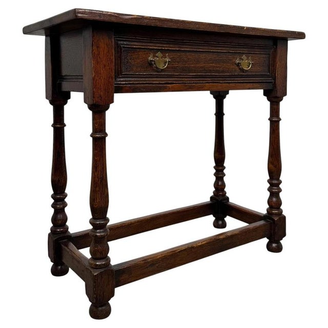 A charming and well-proportioned 20th-century narrow oak side table, combining traditional styling, practical storage and...