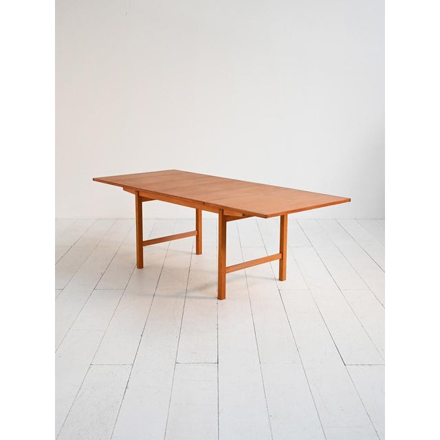 1960s table with teak top and oak frame, featuring a pull-out extension. Extendable dining table from the 1960s, featuring...