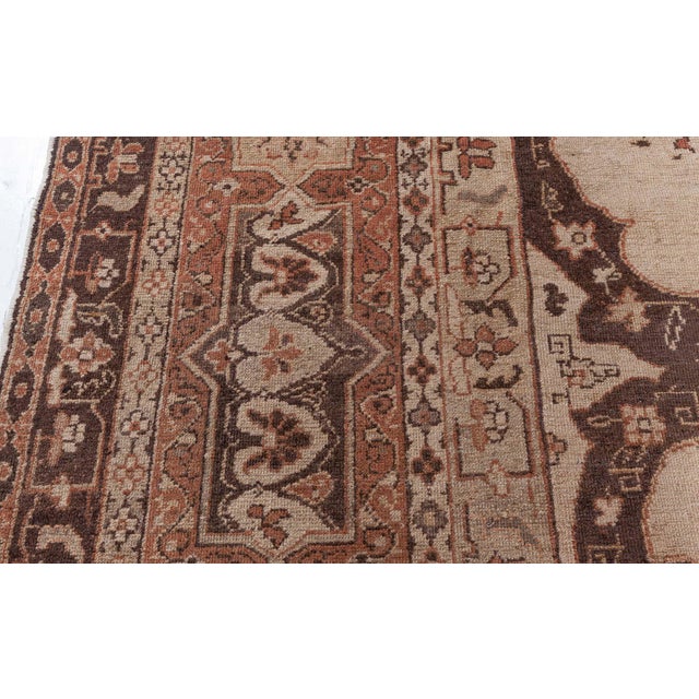 An early 20th century North Indian Amritsar antique rug, the open camel field with an unusual chocolate brown scrolling...