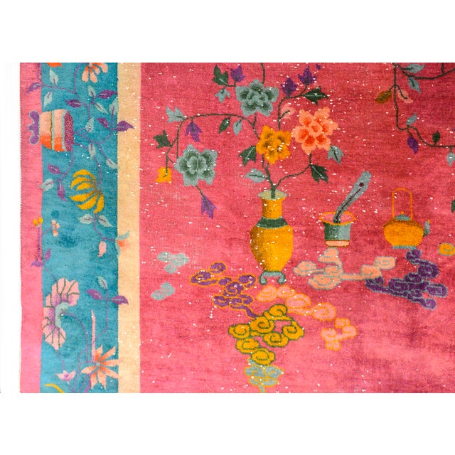 A wonderful bold early 20th century Chinese Art Deco rug with a fuchsia ground surrounded by a thin inner cream satire...