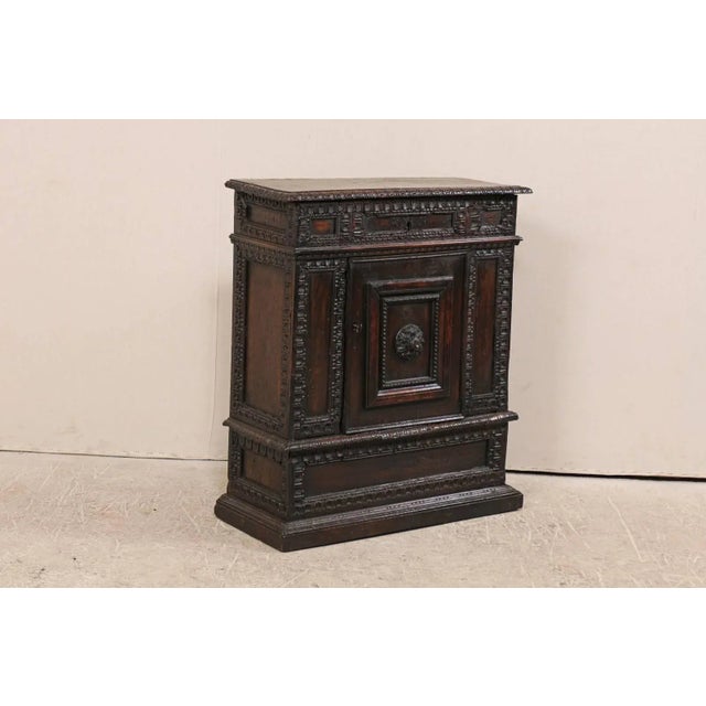 An Italian early 18th century small sized cabinet. This exquisite Italian cabinet, trimmed in richly carved moldings...