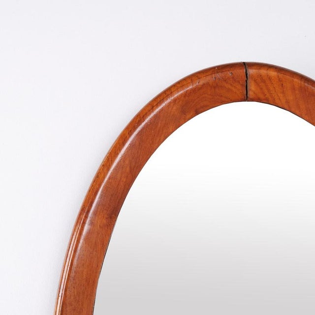 Oval mirror with a walnut frame dating from the 1940s. It features a simple classic design suitable for a hallway, living...