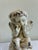 A charming vintage ceramic cherub statue featuring a heavily crackled cream glaze and antiqued finish. The seated angel is...