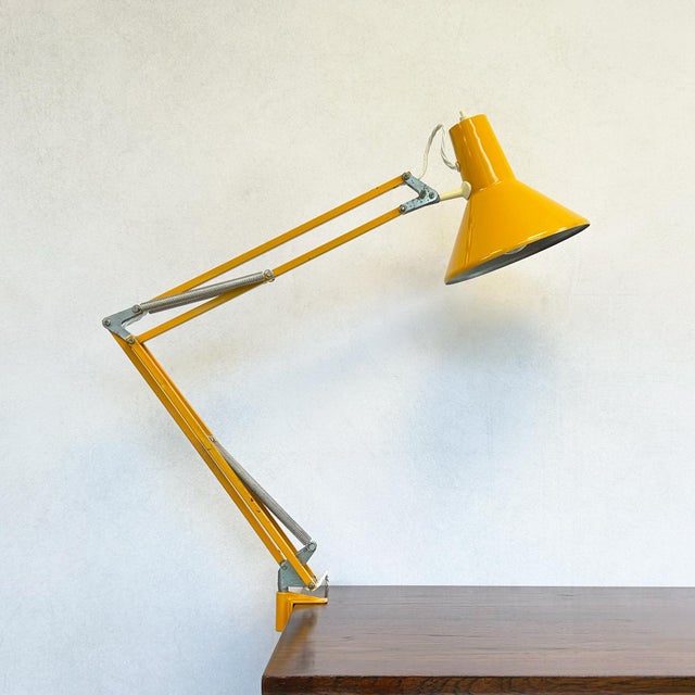 Yellow architect lamp by HCF Denmark, featuring press button on/off switch mounted on shade and desk clamp base. The...