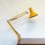 Yellow architect lamp by HCF Denmark, featuring press button on/off switch mounted on shade and desk clamp base. The...