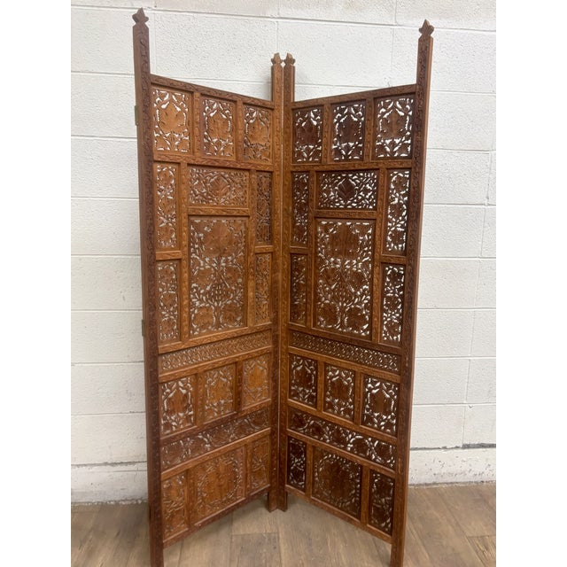 This is a stunning vintage hand carved two panel teak room divider or folding screen, possibly Indian or Thai. The...