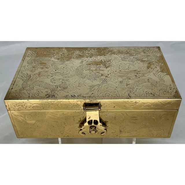 Beautiful polished brass hinged box with engravings of dragons and flowers on all sides. Old velvet lined interior.