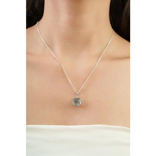This elegant solitaire pendant showcases a luminous 4.96-carat cushion-cut aquamarine, beautifully framed in a sleek bezel...